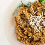 A serving of mushroom barley risotto on a white plate.