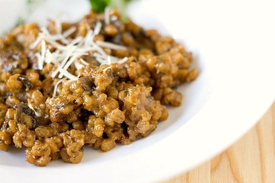 A serving of mushroom barley risotto on a white plate.