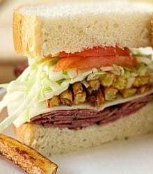 A homemade primanti brother's sandwich cut in half showing all of the sandwich ingredients.