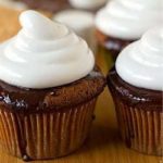 S'mores cupcakes on a wood surface.