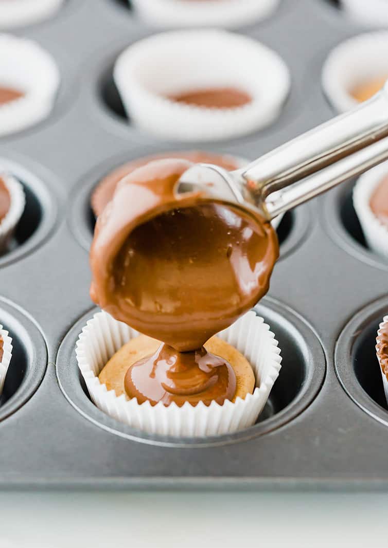 Scooping melted chocolate on top of peanut butter filling.