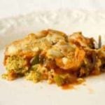 A serving of garden zucchini pizza casserole on a white plate.
