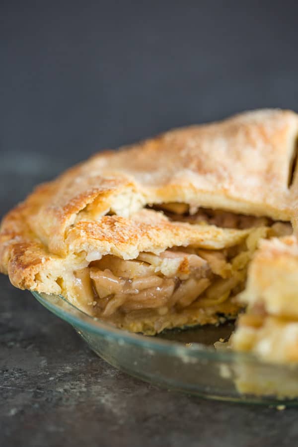 A fresh baked apple pie sliced into so you can see the filling.