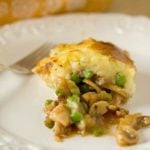 Serving of turkey pot pie on a white plate with a fork.