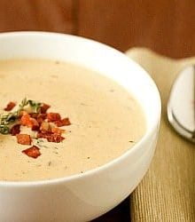 Cheddar cheese soup in a white bowl.