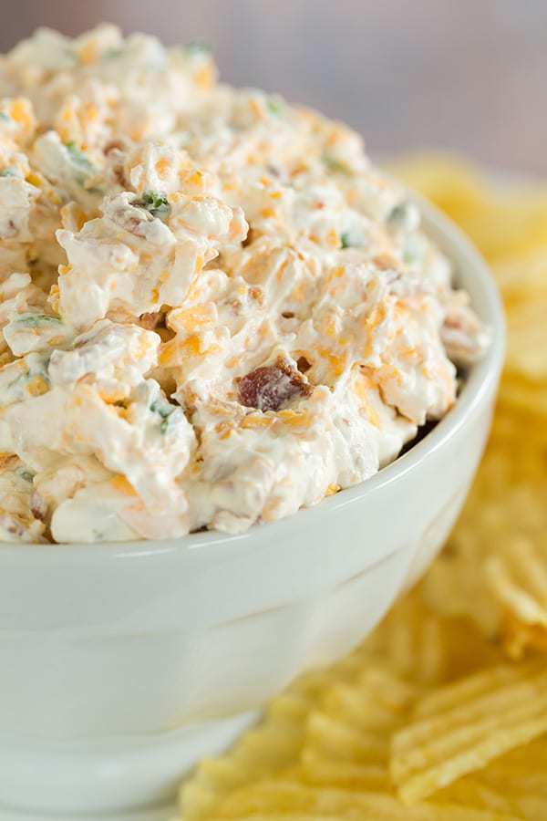 This loaded baked potato dip combines all of the fantastic flavors of a classic loaded baked potato - sour cream, bacon, cheese and scallions. Scoop away with potato chips!