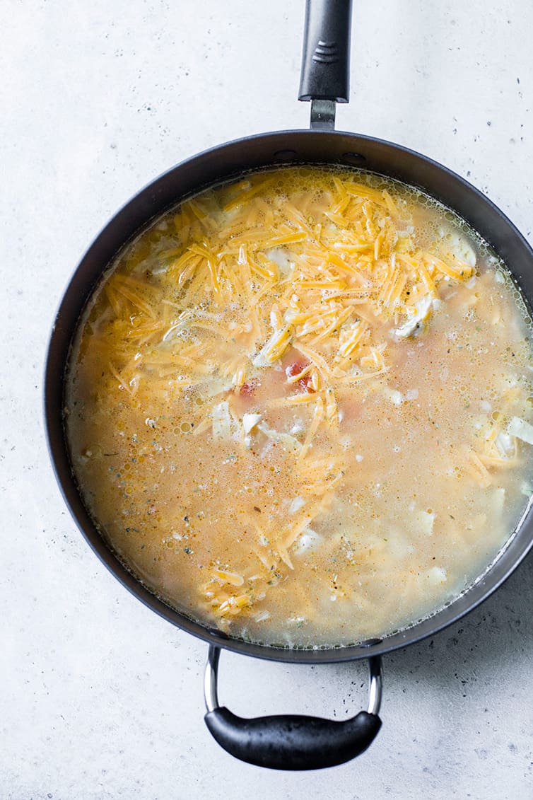 A pot with all of the ingredients for chicken tortilla soup inside.