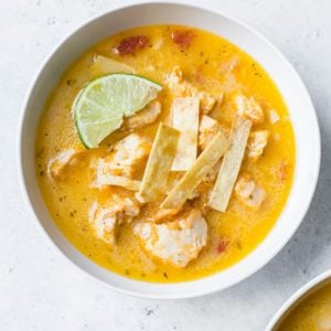 An overhead shot of a bowl of chicken tortilla soup.