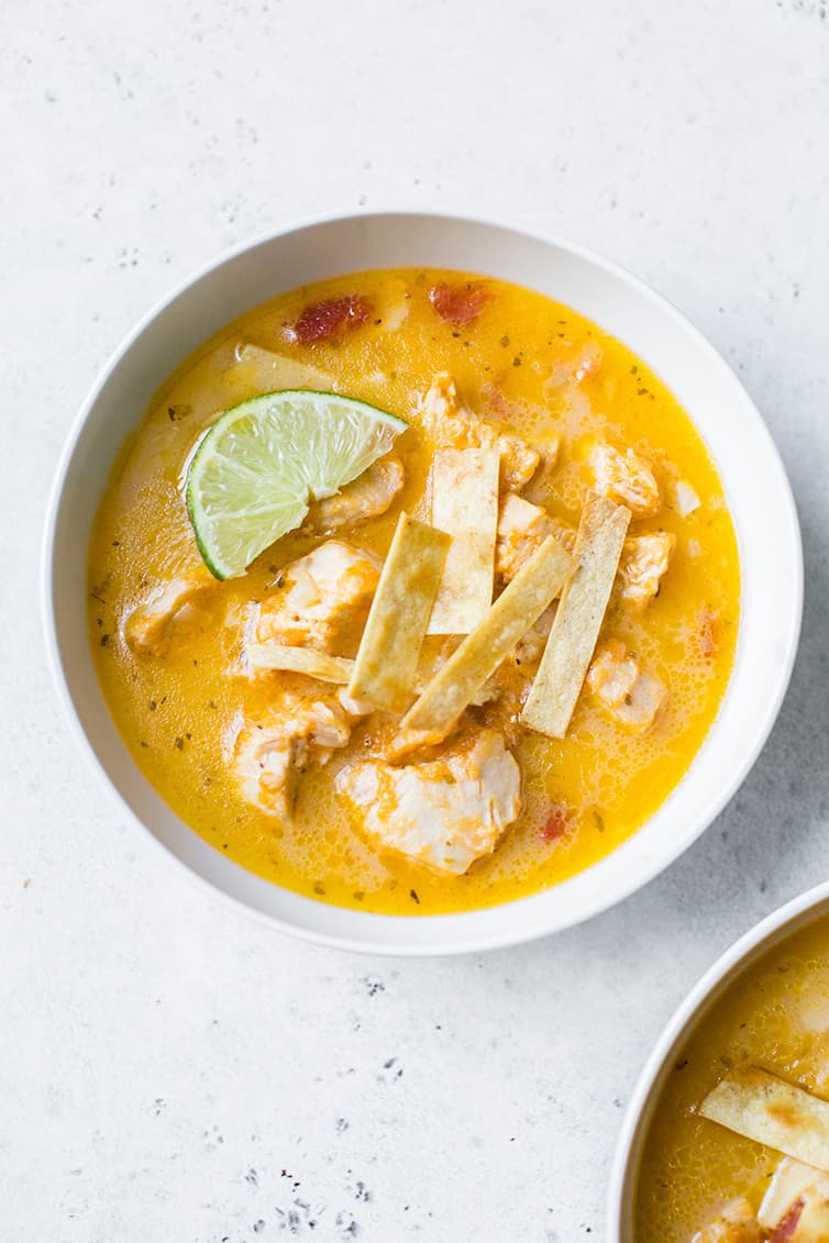 An overhead shot of a bowl of chicken tortilla soup.