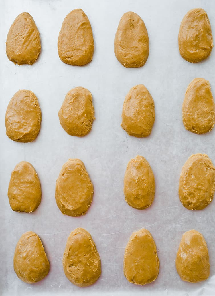 Shaped peanut butter eggs on a pan, before being coated in chocolate.