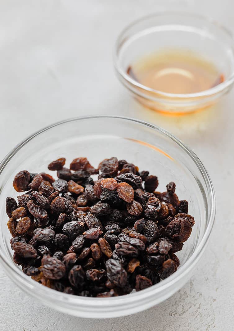 A bowl of raisins with a smaller bowl of bourbon.