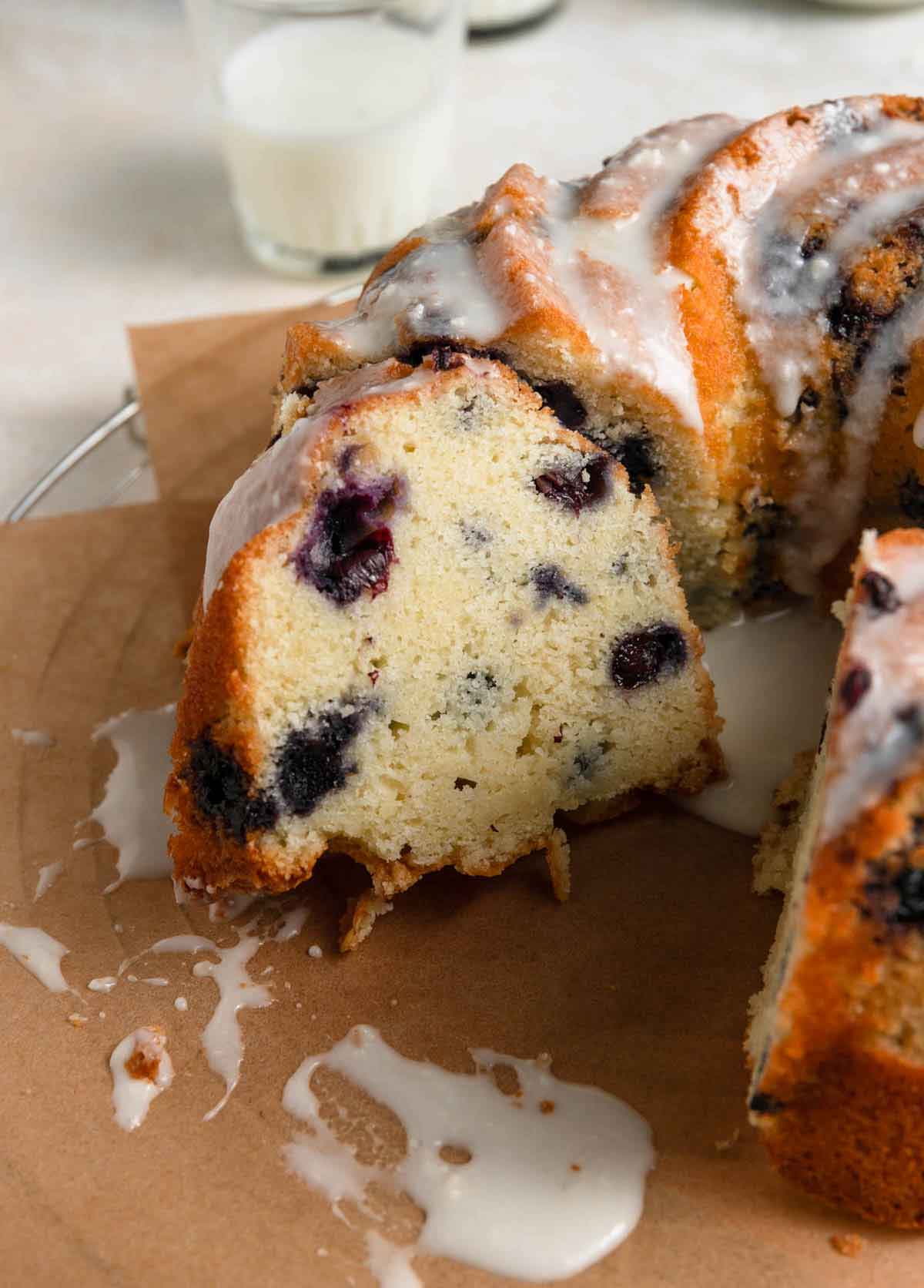 Close up photo of slice of lemon blueberry bundt cake leaning against cut side of the cake.