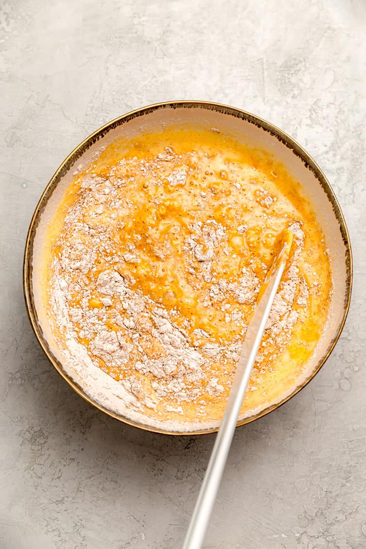 A mixing bowl with batter for a pumpkin roll.