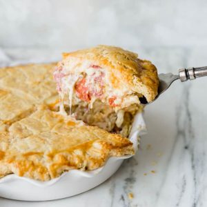 A slice of Italian Easter Pie being lifted out of the pie plate.