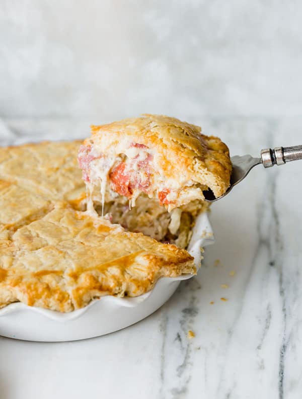 A slice of Italian Easter Pie being lifted out of the pie plate.