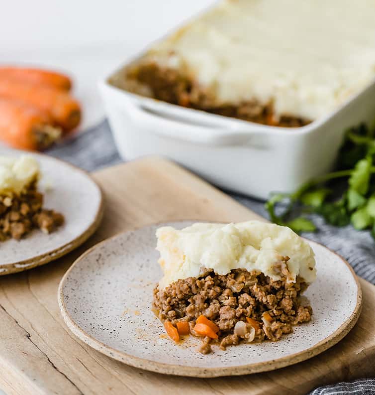 A plate of shepherd's pie with the casserole dish in the background.