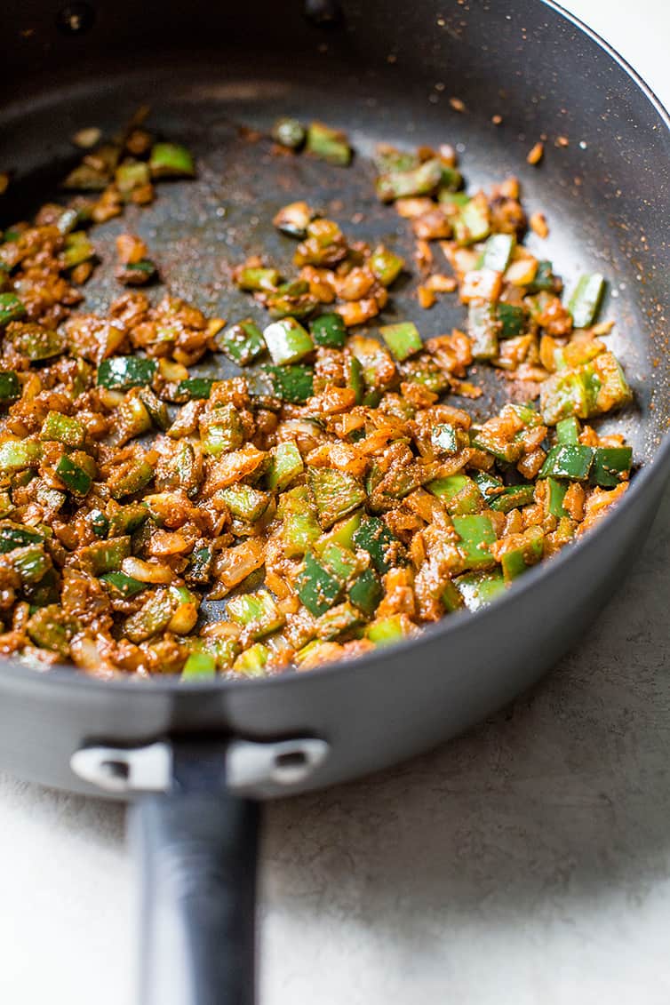 Onion, peppers and seasonings sauteed in a pot.