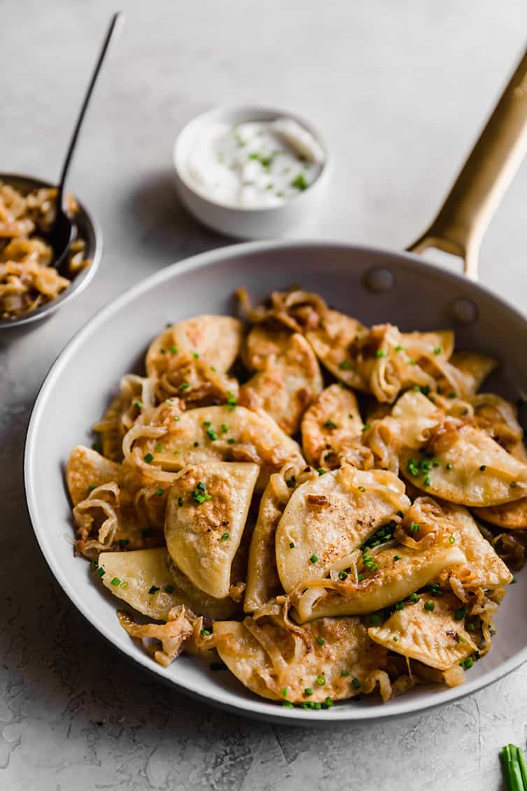 A frying pan with sauteed pierogi and caramelized onion.