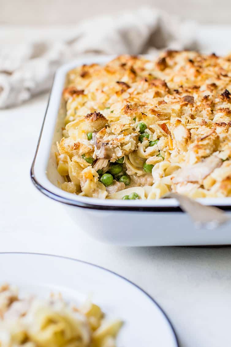A head-on view of a pan of tuna noodle casserole with a serving scooped out.