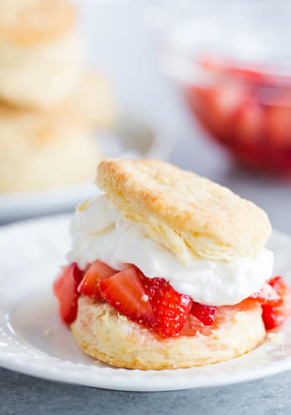 Assembled strawberry shortcake - split buttermilk biscuit with macerated strawberries and fresh whipped cream.