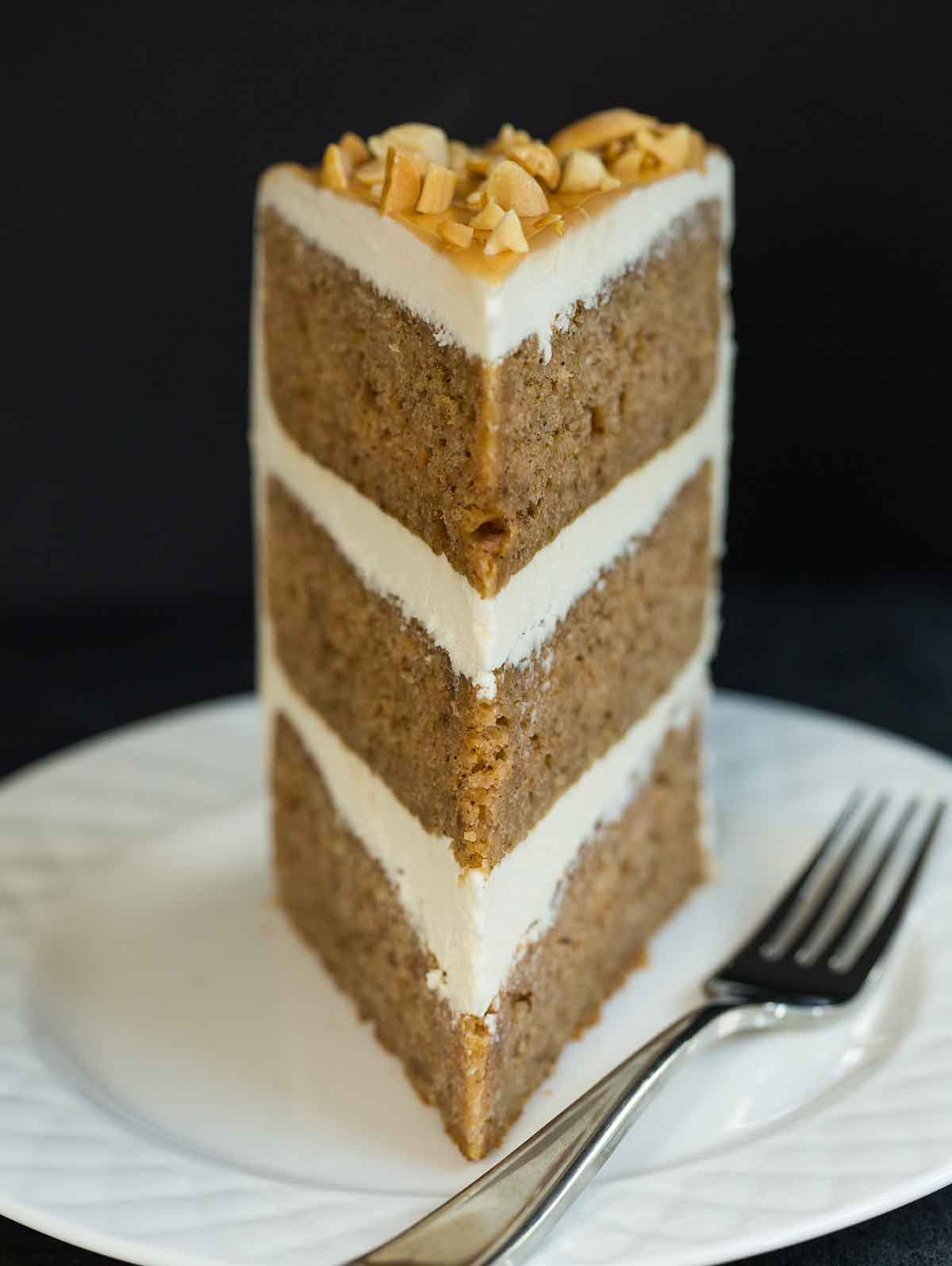 Slice of triple layer salted caramel apple cake on a white plate.