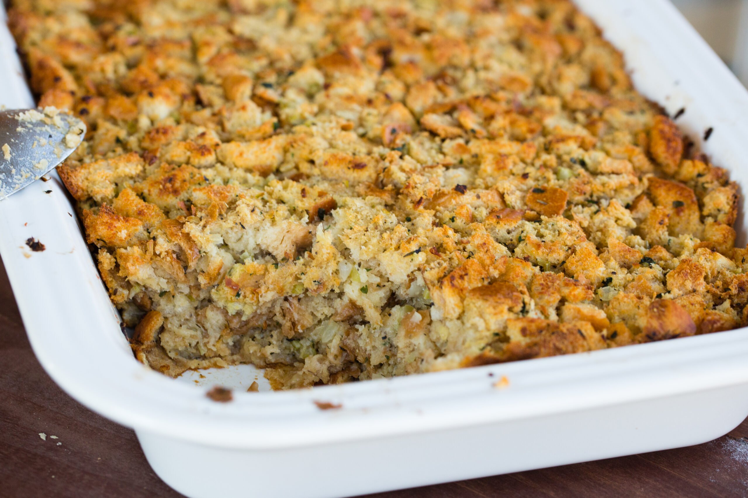 Pan of classic bread stuffing with a scoop removed.