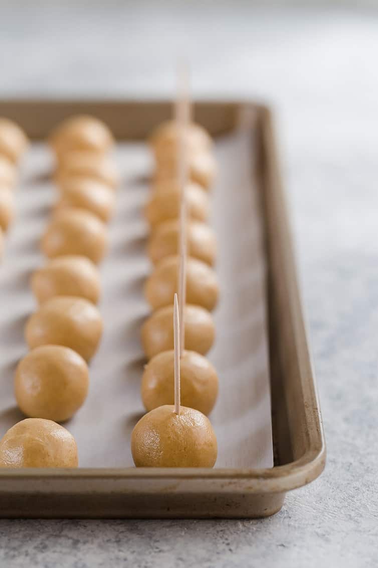 Buckeyes rolled into balls with toothpicks inserted on top.