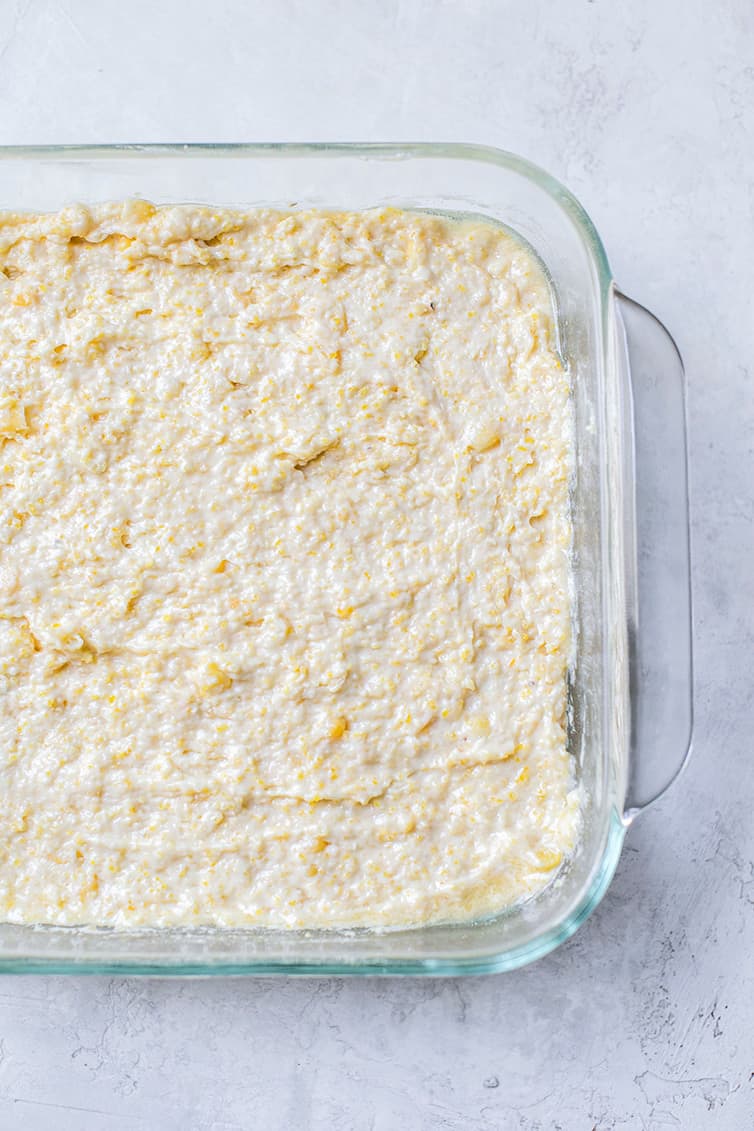 Cornbread batter spread into a pan before baking.