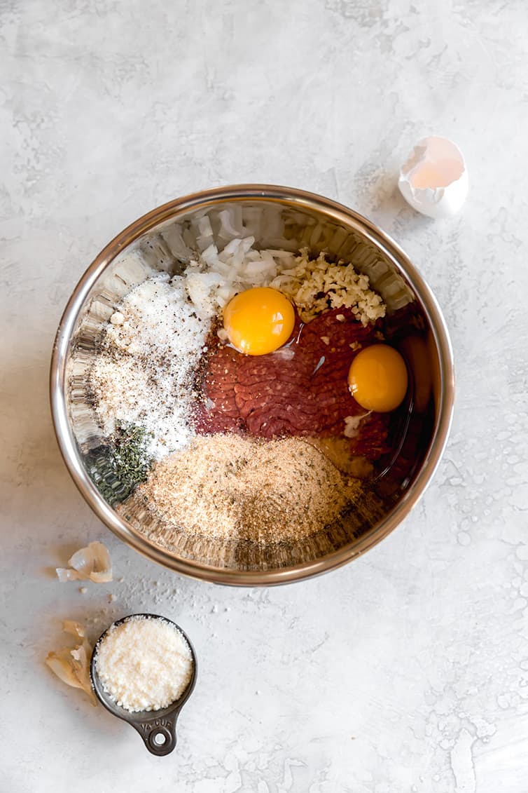 Ingredients for Italian meatball recipe in a stainless steel bowl.