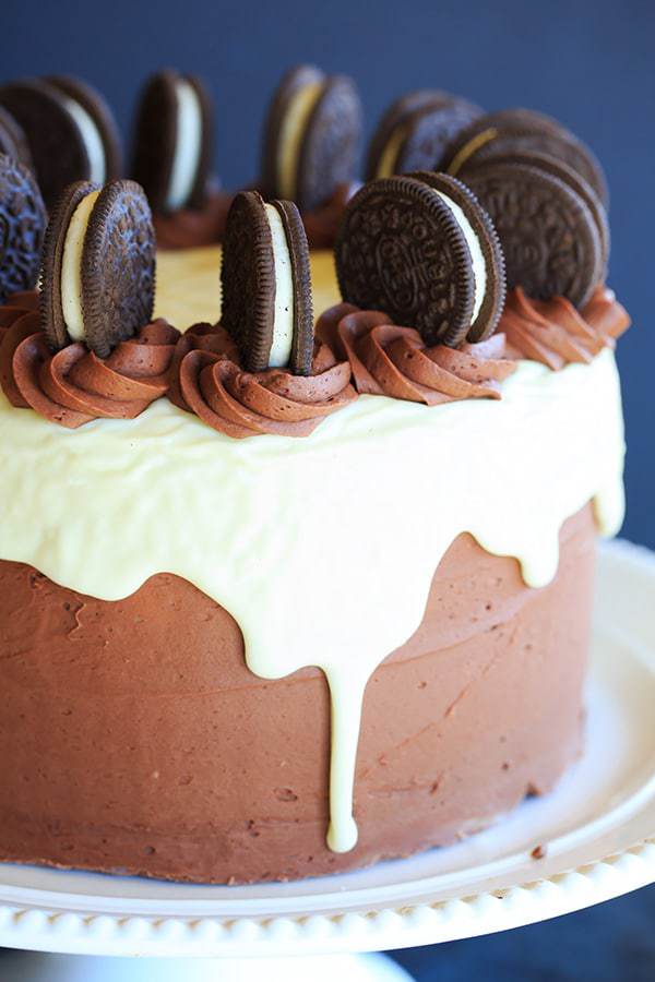 The ULTIMATE Cookies and Cream Oreo Cake - A triple layer chocolate cake with cookies and cream filling, chocolate fudge frosting, white chocolate glaze and more Oreos on top! | https://apex-male.info/cookies-and-cream-oreo-cake/