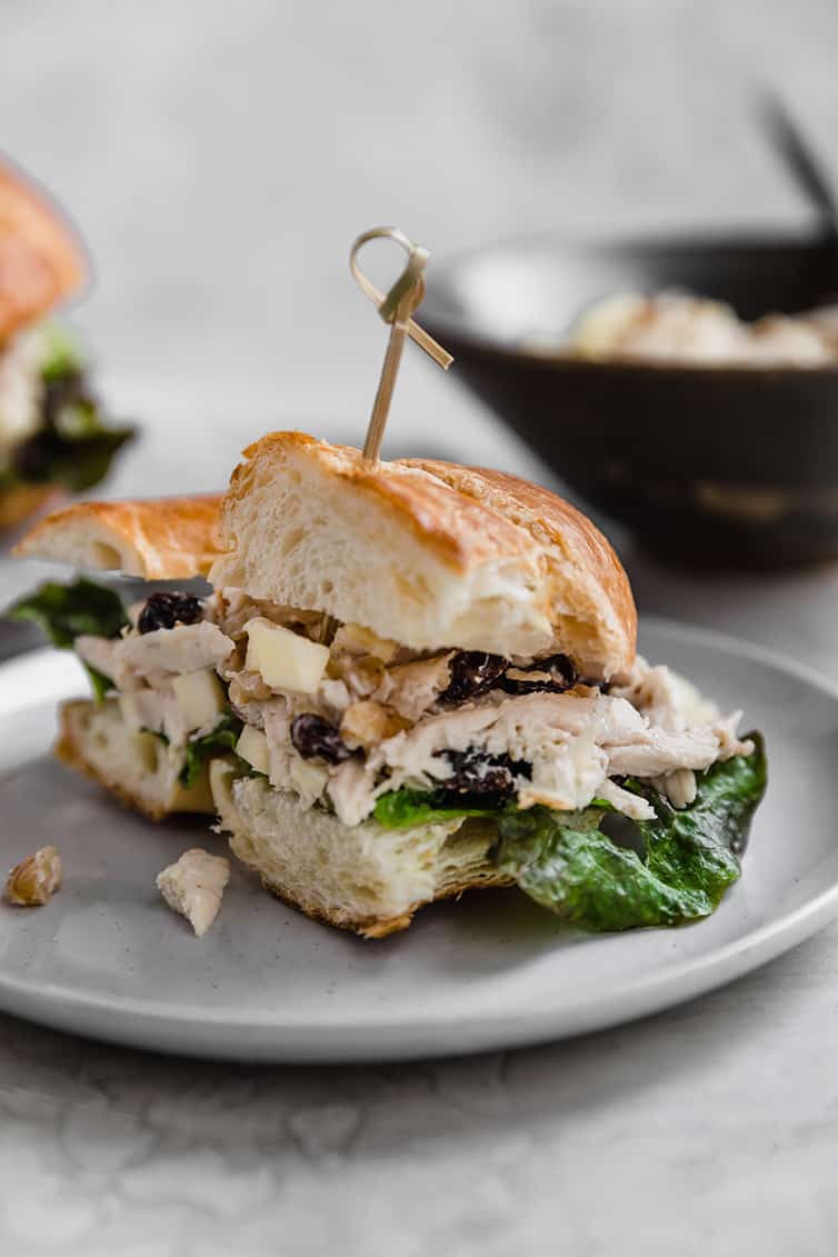 A chicken salad sandwich on croissant cut in half.