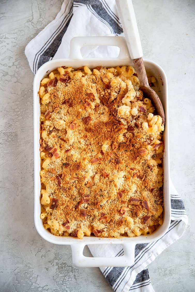 A white casserole dish with baked mac and cheese