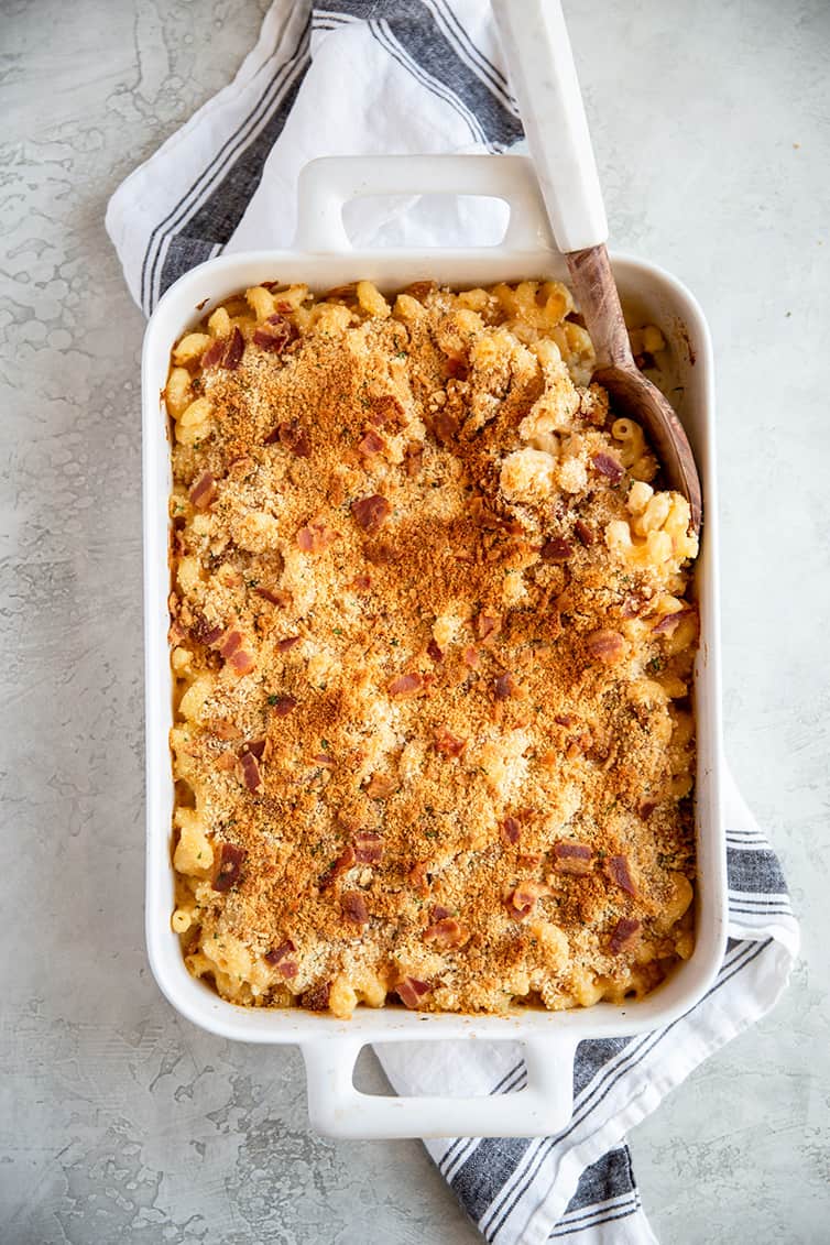 A white casserole dish with baked mac and cheese