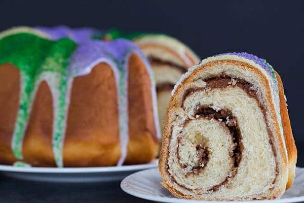 A festive King Cake for Mardi Gras - filled with a pecan, brown sugar and cinnamon swirl - baked into a Bundt pan and decorated with colored sanding sugars.