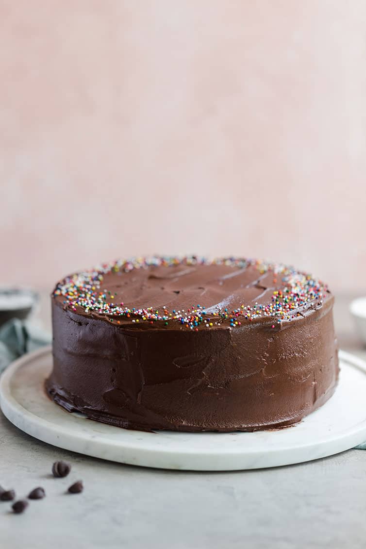 Cake covered in chocolate frosting on a platter.