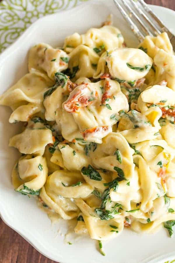 Tortellini in Parmesan-Cream Sauce with Spinach and Sun-Dried Tomatoes - An easy, AMAZING dinner ready in less than 30 minutes! Perfect for a weeknight meal or your next dinner party.