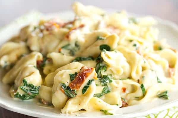 Tortellini in Parmesan-Cream Sauce with Spinach and Sun-Dried Tomatoes - An easy, AMAZING dinner ready in less than 30 minutes! Perfect for a weeknight meal or your next dinner party.