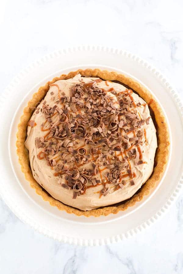 Milky Way Tart - A pate sucree crust is filled with caramel sauce and whipped milk chocolate ganache, then topped with a drizzle of caramel and chocolate curls.