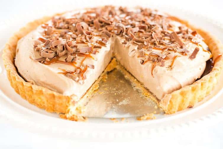 Milky Way Tart - A pate sucree crust is filled with caramel sauce and whipped milk chocolate ganache, then topped with a drizzle of caramel and chocolate curls.