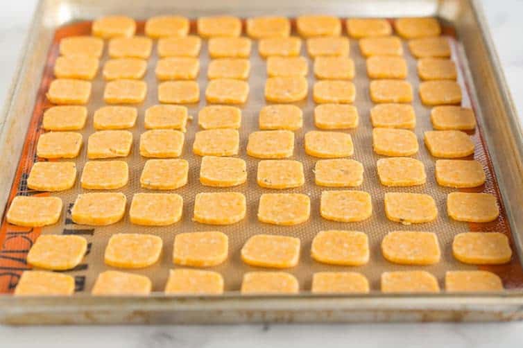 Spicy cheese crackers on a sheet pan, waiting to be baked.