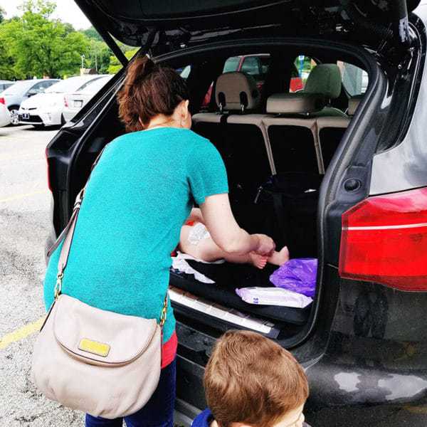 Changing a poopy diaper in a parking lot.