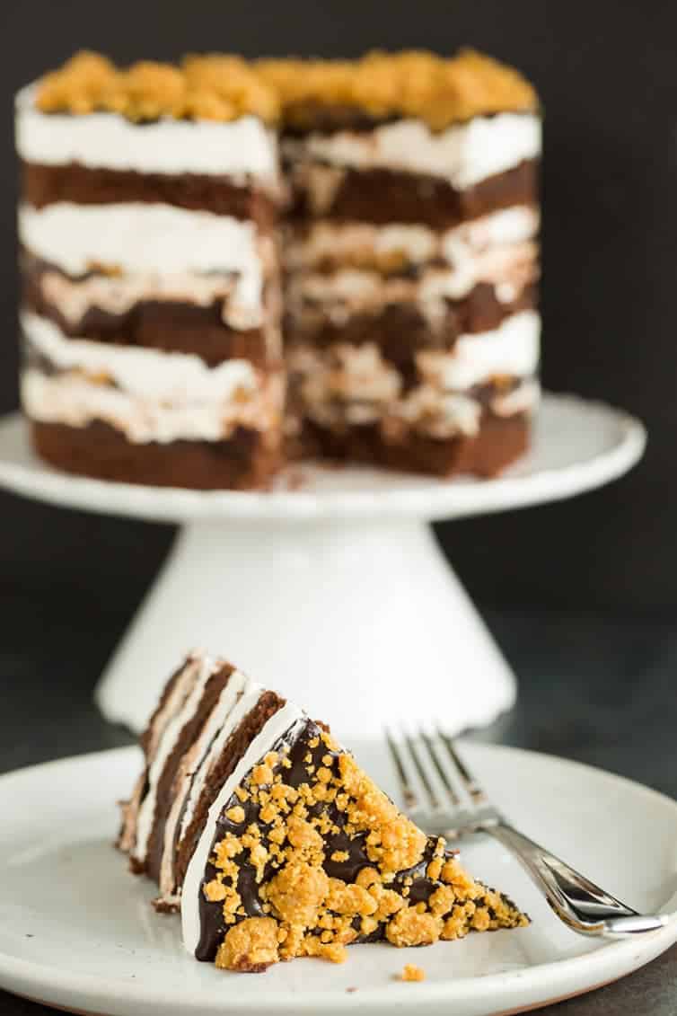 A slice of s'mores cake sitting in front of the sliced cake.