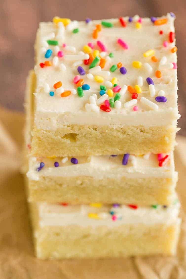 An overhead shot of a stack of frosted sugar cookie bars.