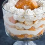 Layers of chopped doughnuts and coffee whipped cream in a trifle bowl.