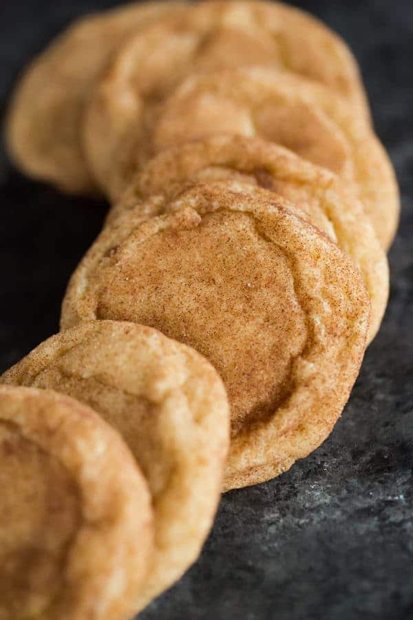 A display of snickerdoodle cookies on a dark serving plate.