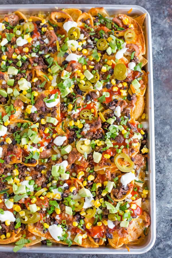 A sheet pan full of loaded nachos.