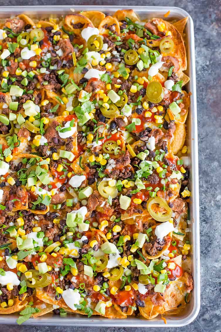 A sheet pan full of loaded nachos.