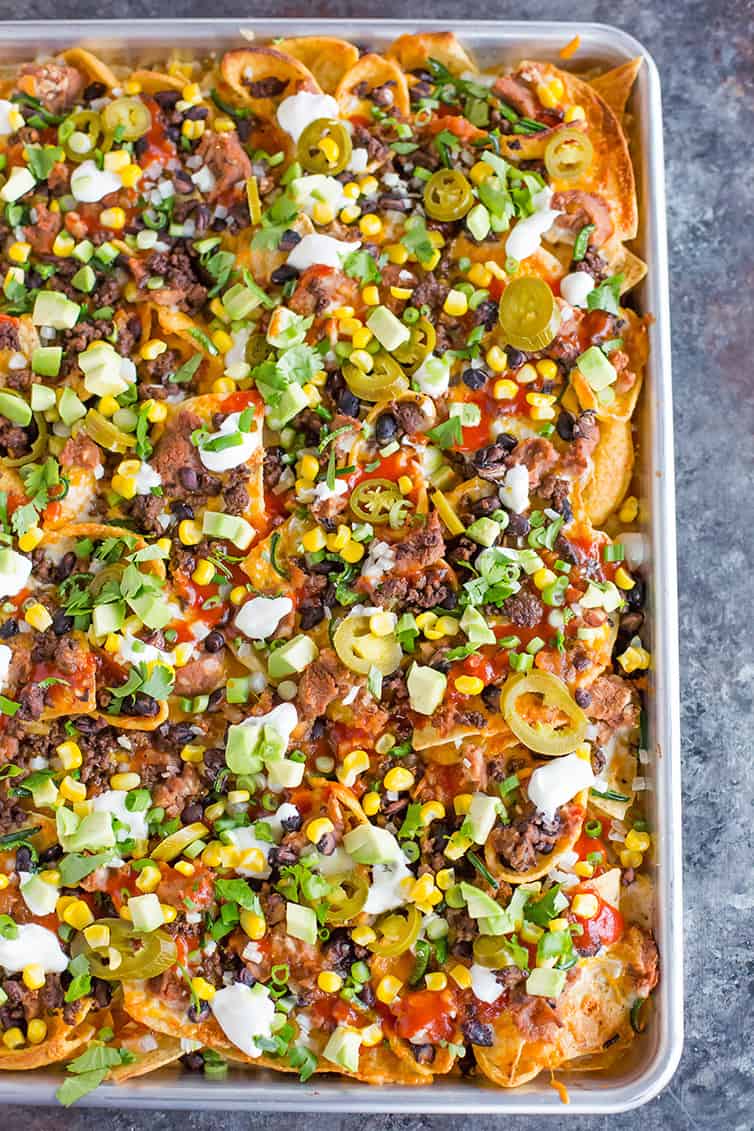 A sheet pan full of loaded nachos.