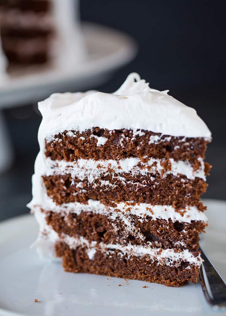 A side view of a slice of devil's food cake with 7 minute frosting.