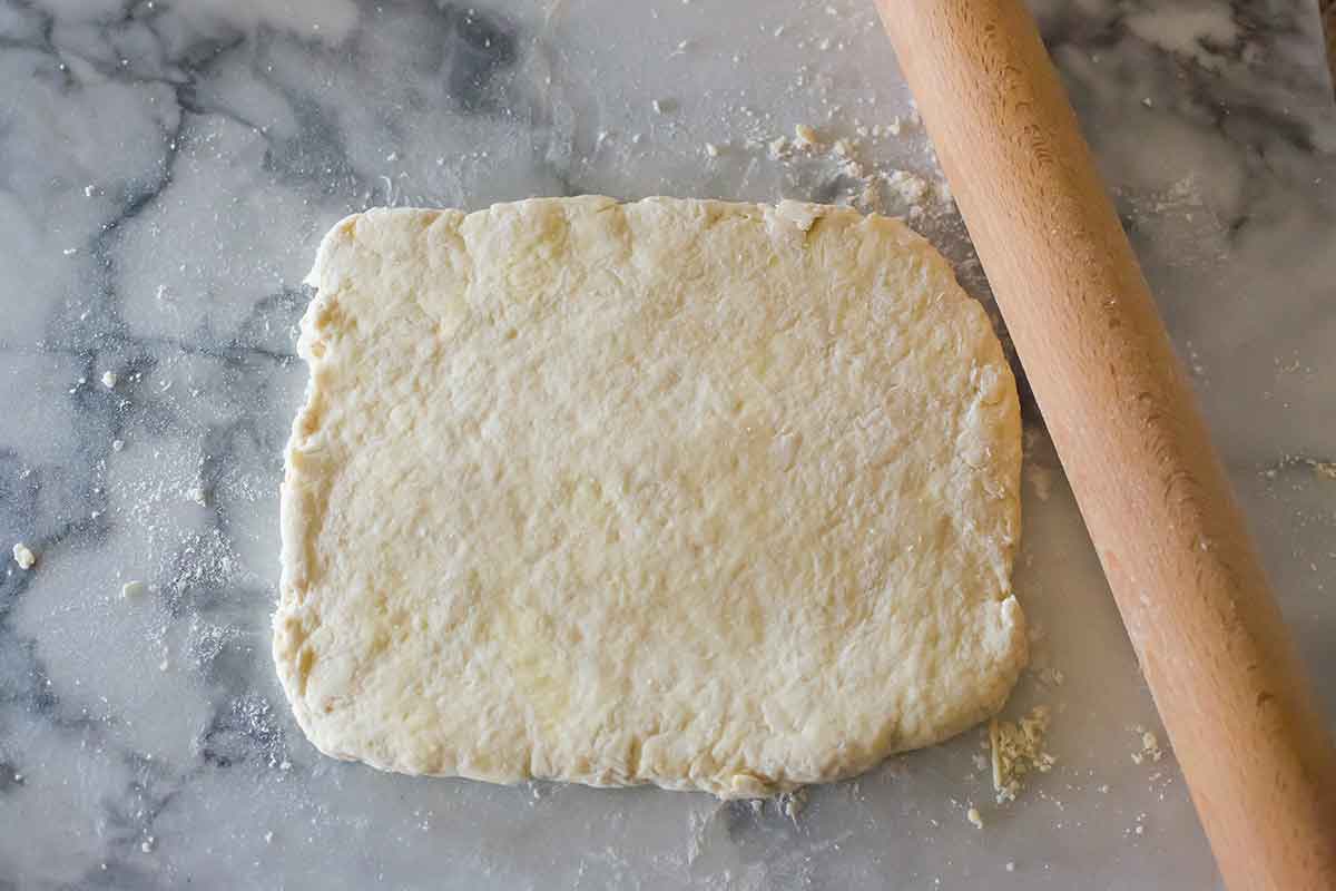 Biscuit dough patted and rolled into an even rectangle.
